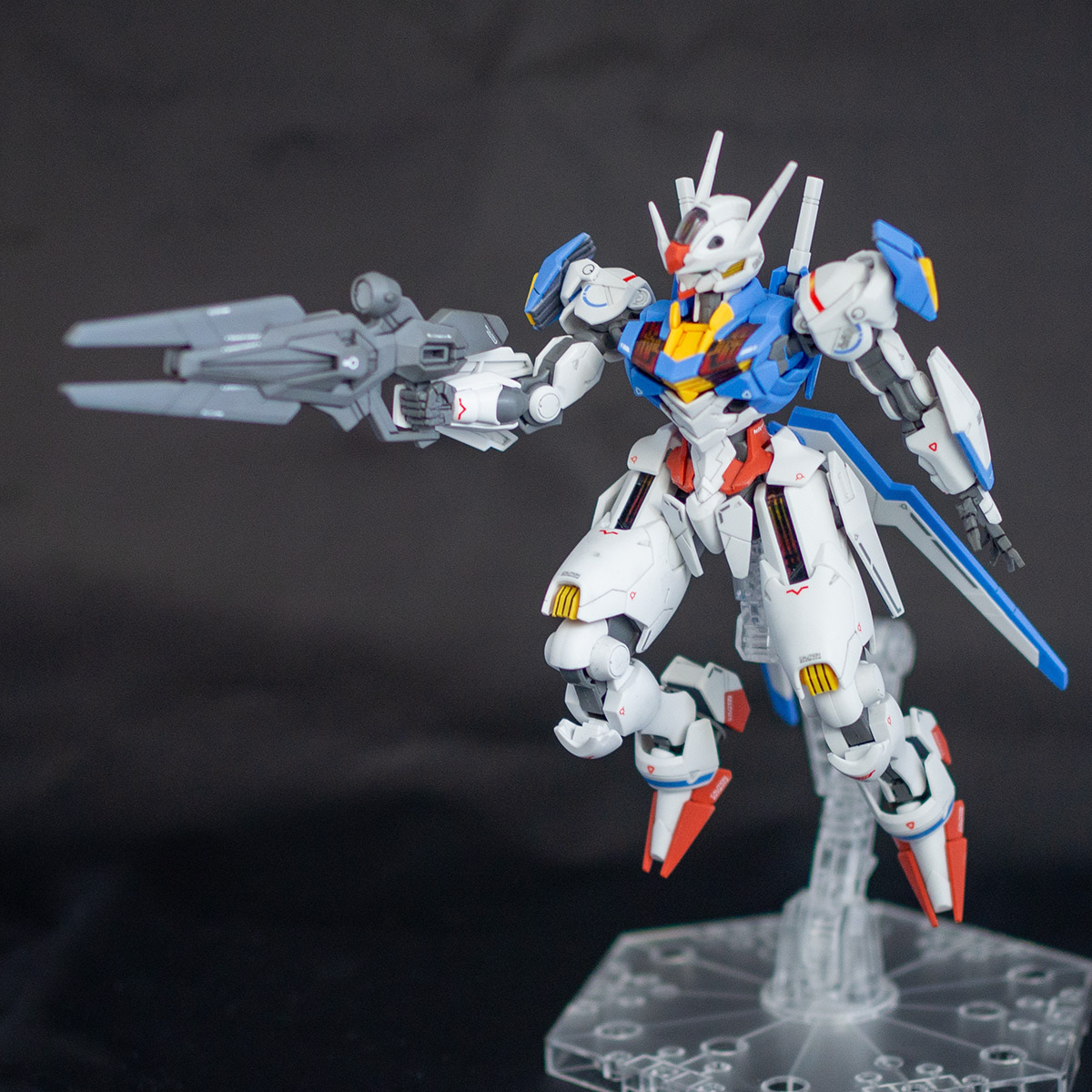 Completed high grade Gundam Aerial on a stand pointing a beam riffle to the left.