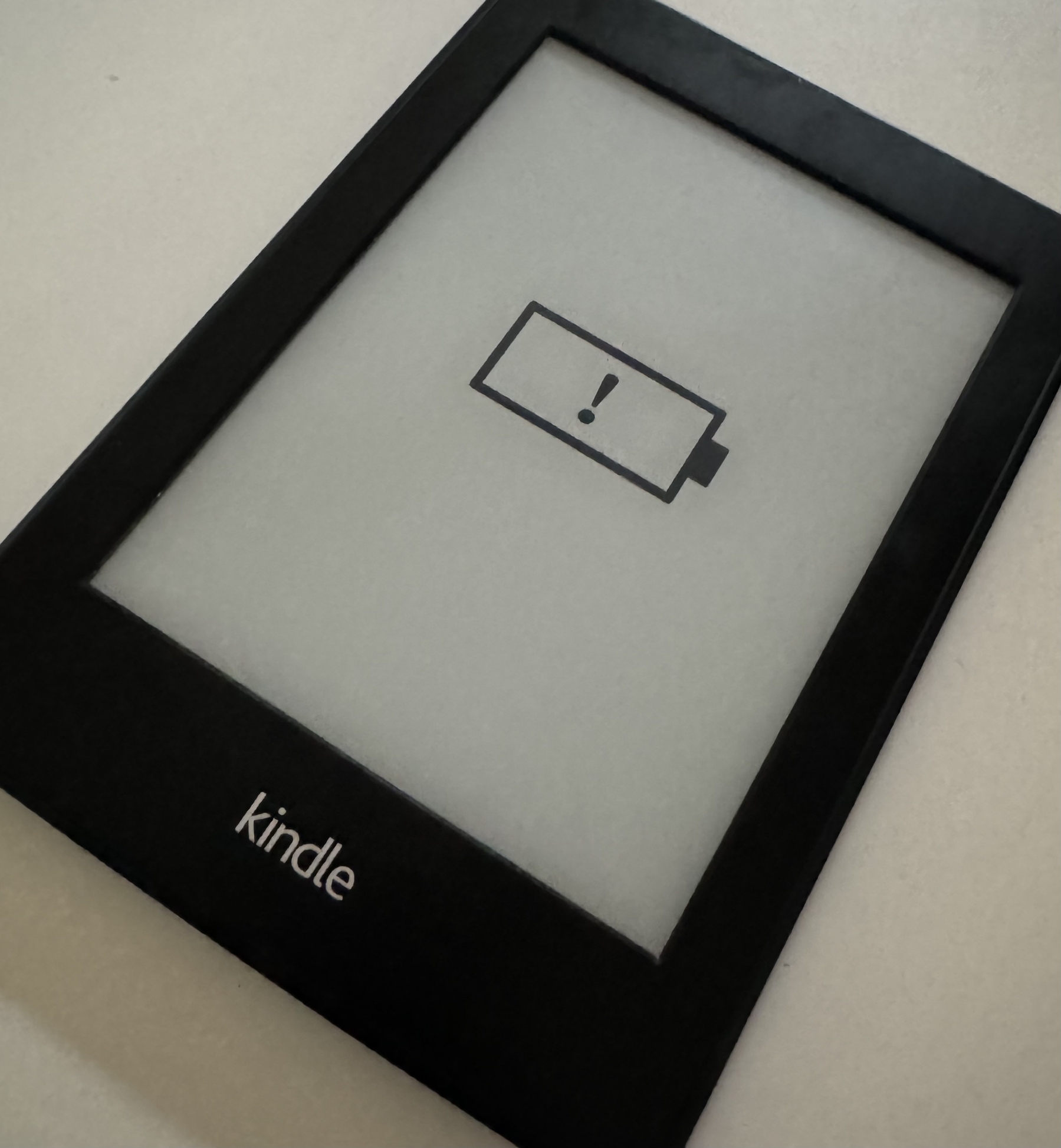 a kindle eReader showing an exclamation mark enclosed by a battery