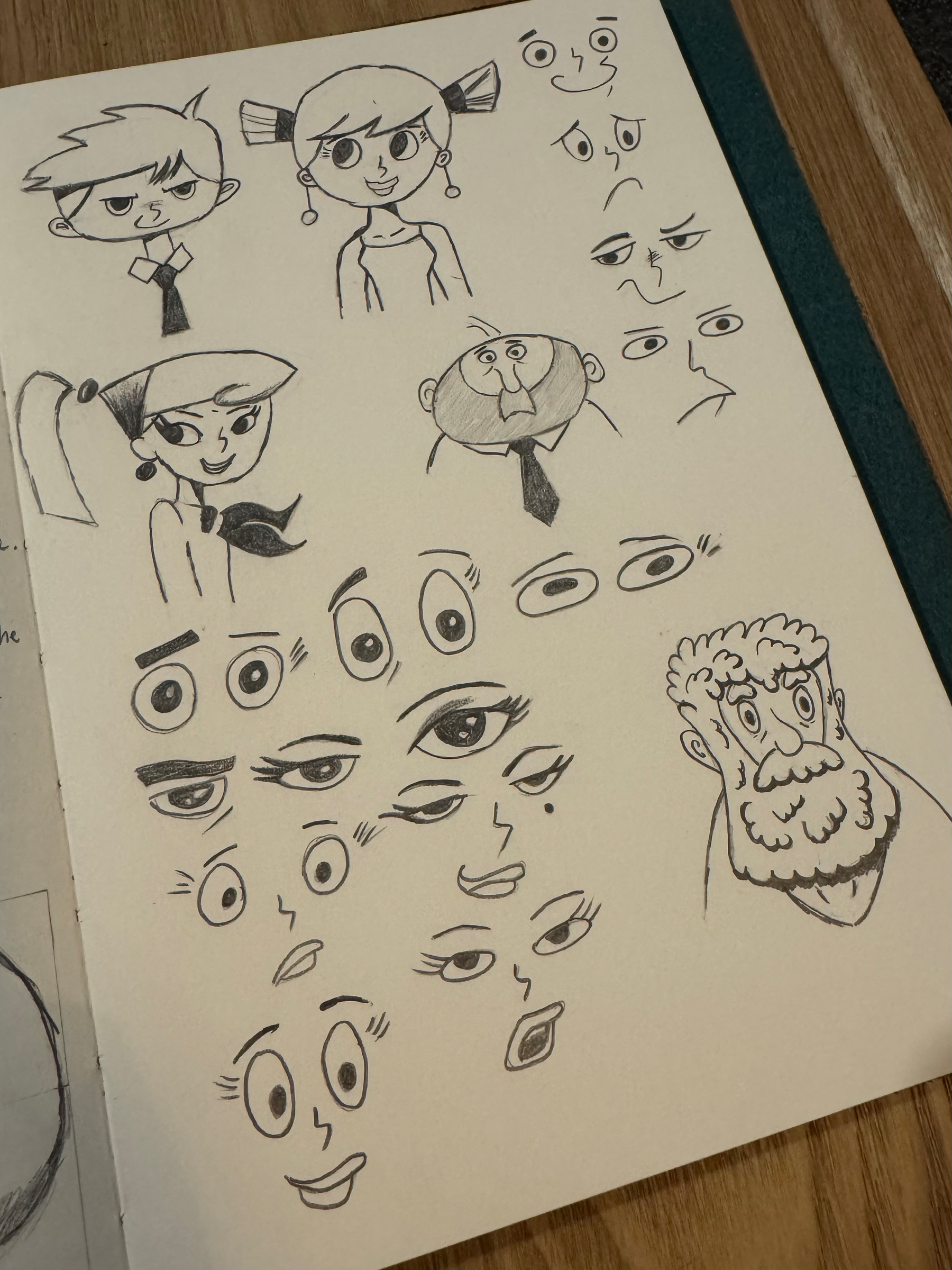 A sketchbook page features cartoon-style drawings of characters and various eye expressions.