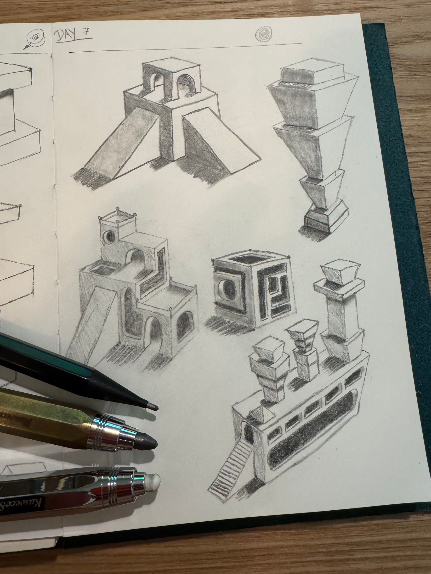 A sketchbook page features various geometric, architectural pencil sketches, including abstract structures and designs, with three pencils resting nearby.