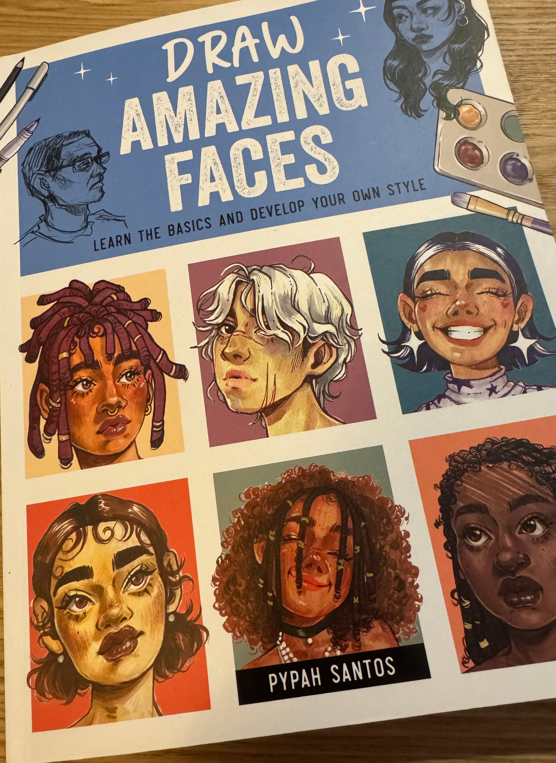 A book cover titled Draw Amazing Faces features six illustrated portraits and art tools, offering guidance on learning and developing drawing styles.