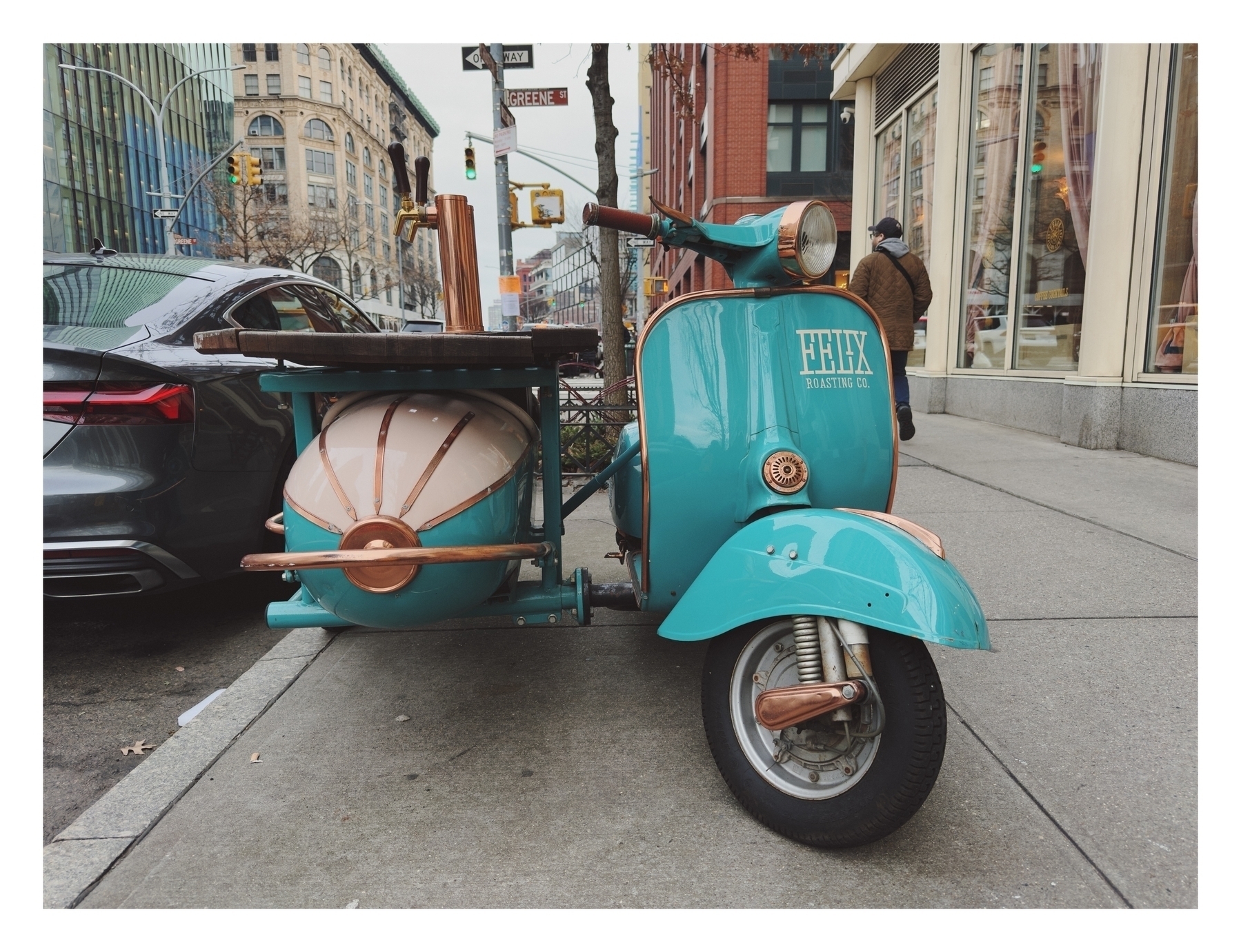 A turquoise scooter with a sidecar, both outfitted with coffee-making equipment, parked on an urban street. Text on scooter: “FELIX ROASTING CO.