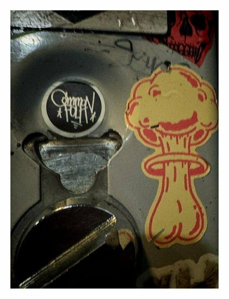 picture of a hand dryer in a bar bathroom with a sticker that is a cartoon of testicles as an atomic bomb mushroom cloud on it