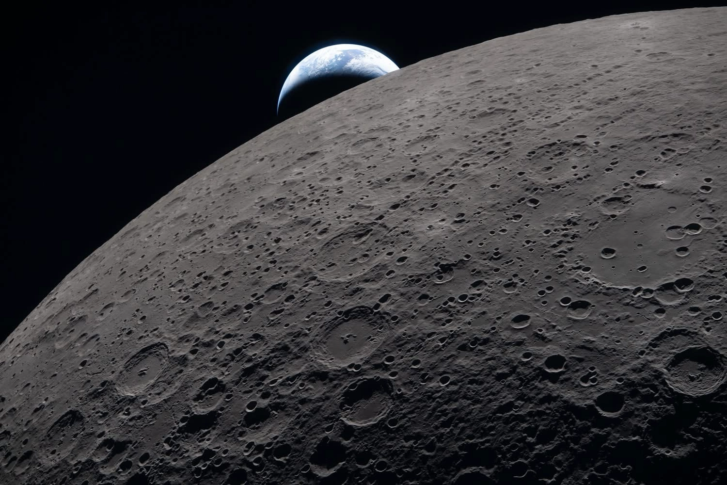 Auto-generated description: A view of Earth rising over the cratered surface of the Moon.