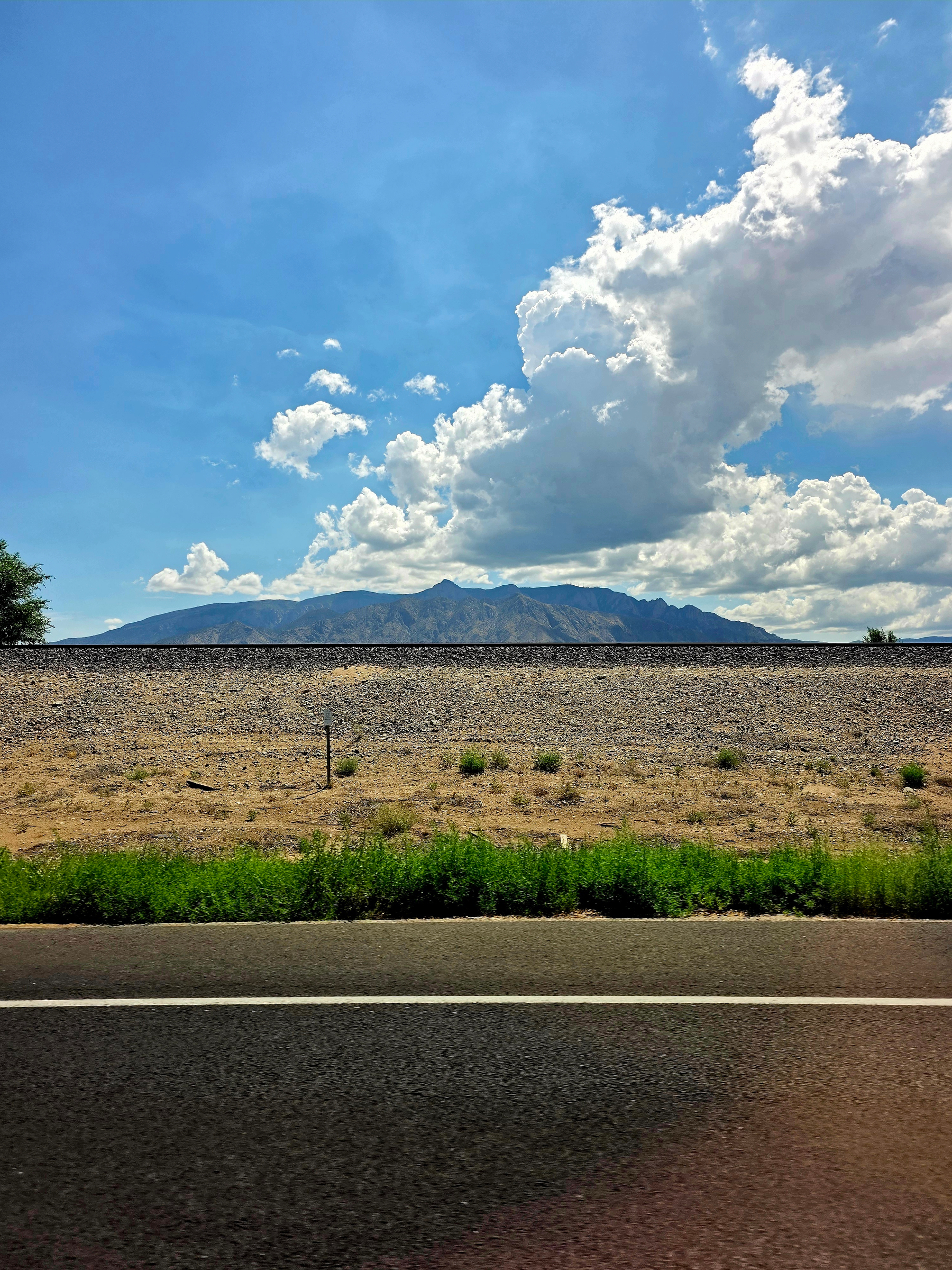 Sandia Mountains under a big cloud, seen from NM-313 near Bernalillo