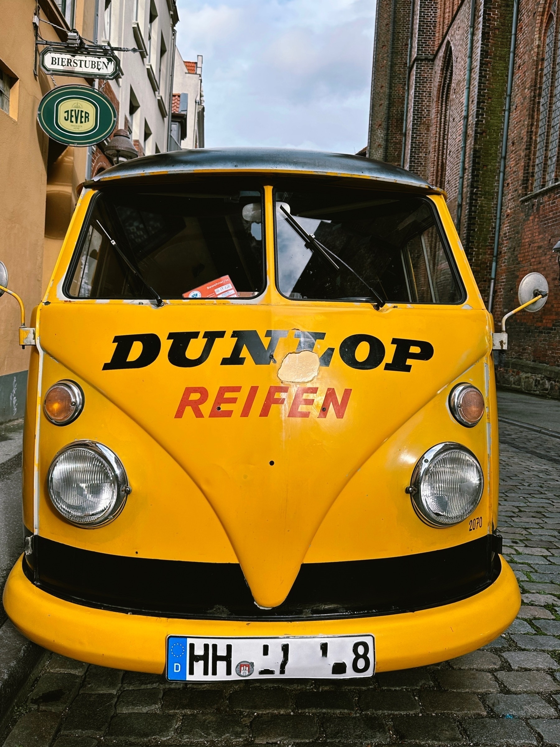 Front of a yellow VW Bulli T1 with "Dunlop Reifen" written on it.