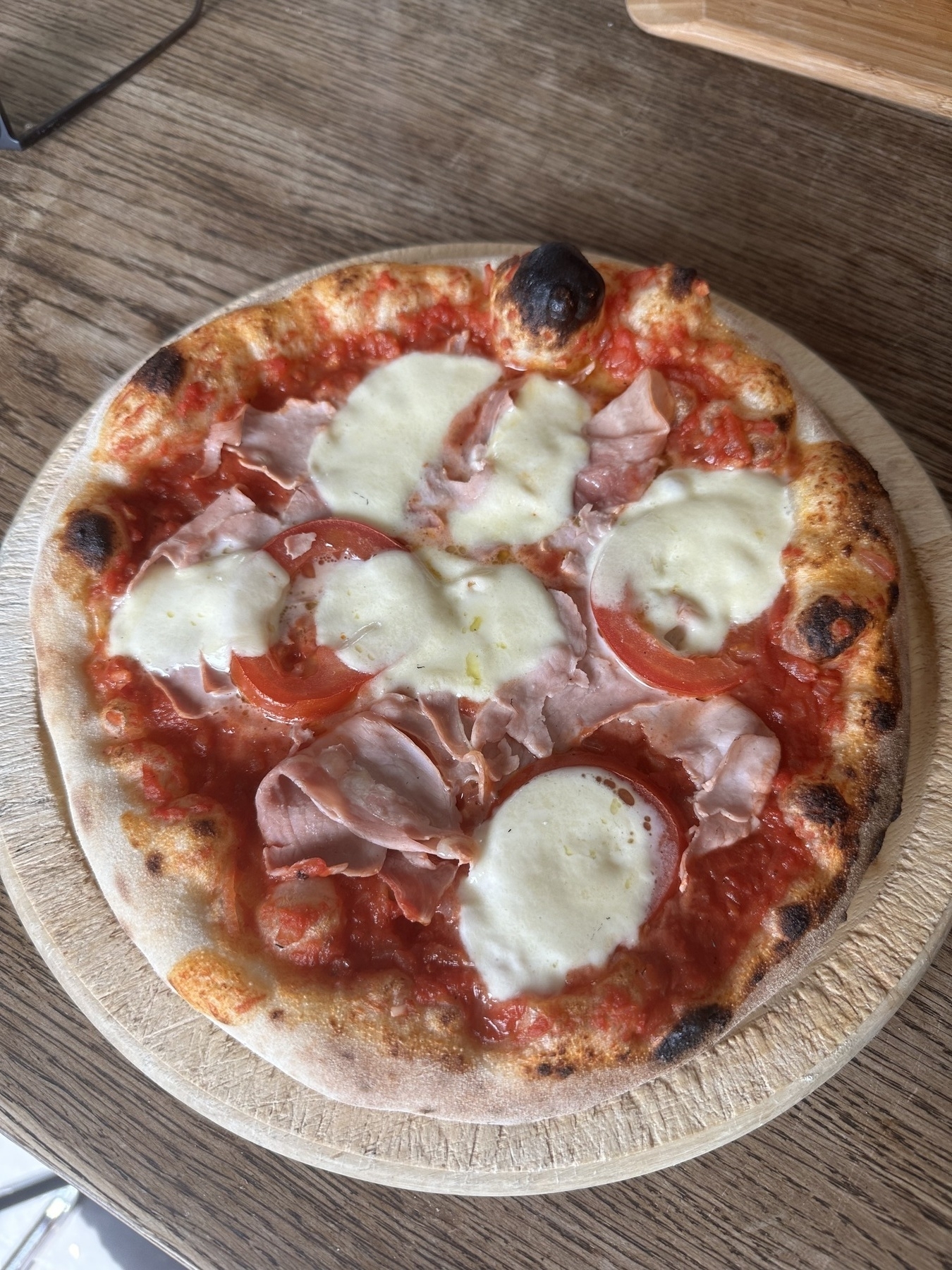 self made pizza with an Oonie pizza ofen on a wooden plate