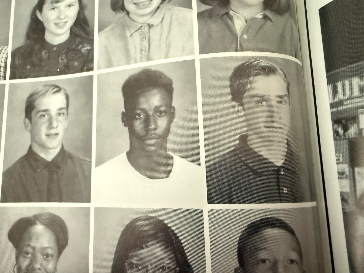 Yearbook photos of two twin guys separated by another student