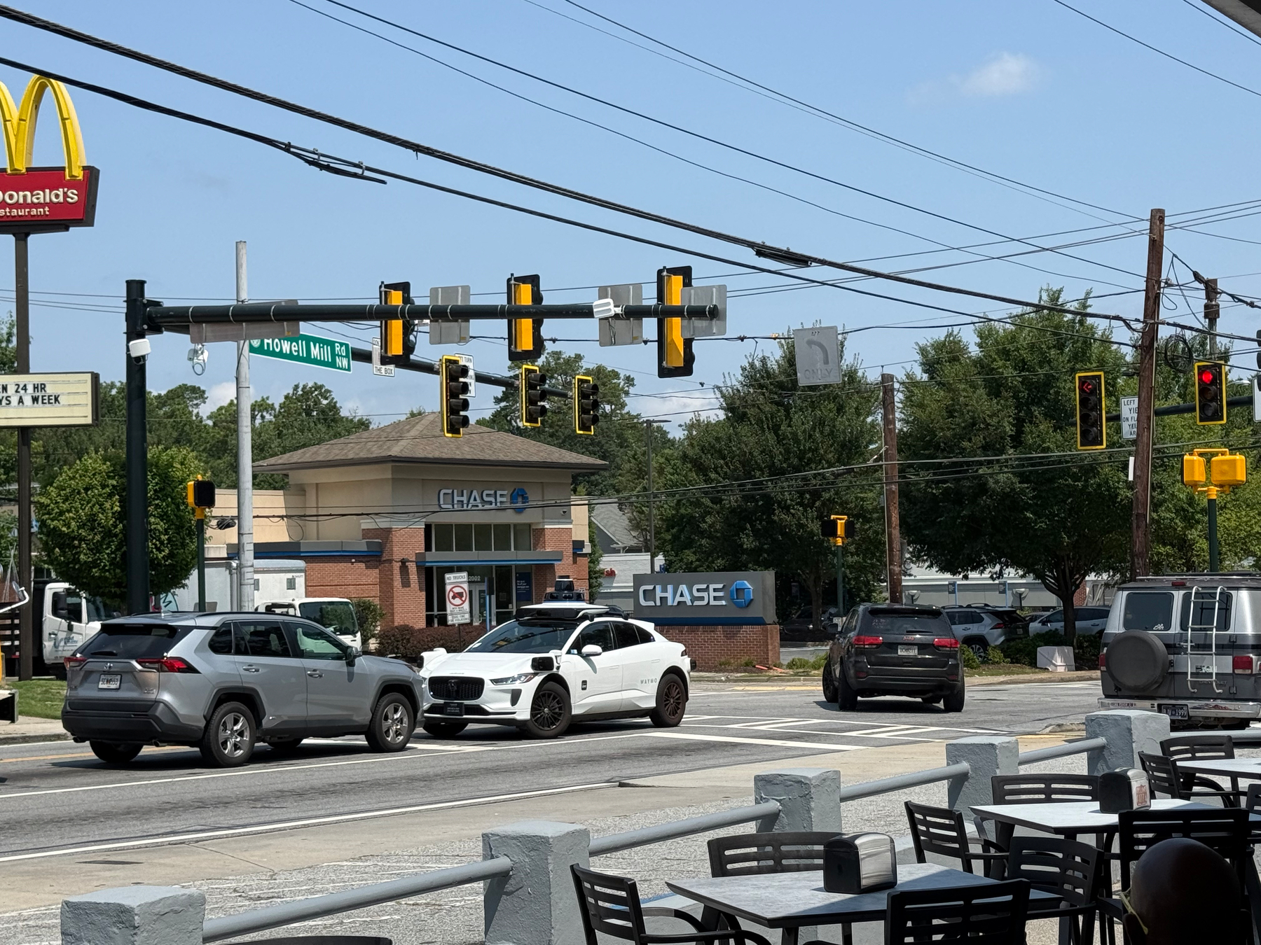 Photo taken at an intersection near me. A Waymo is face to face in the opposite lane’s left turn lane.