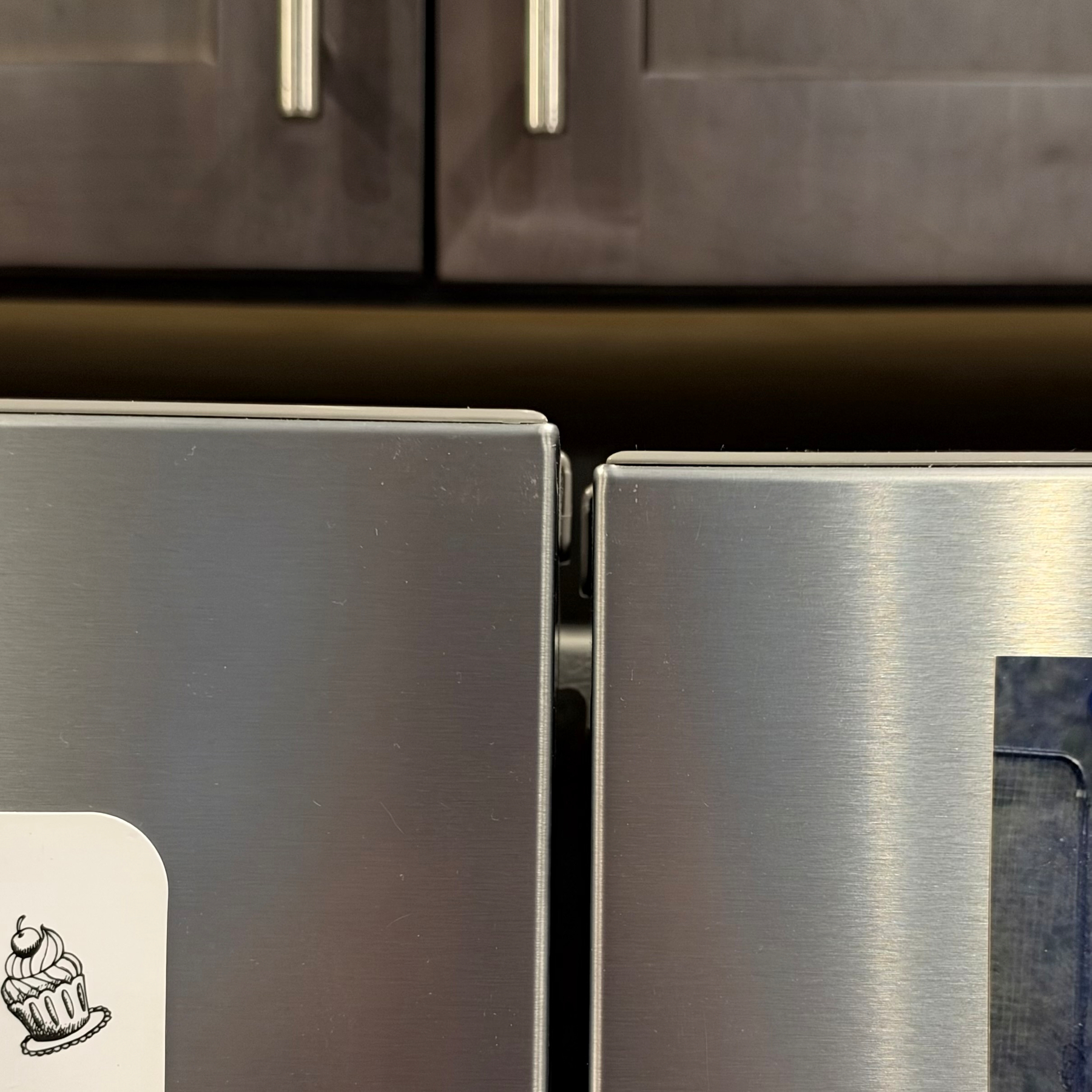 A photo of the top of my fridge, where the doors are not at the same height.