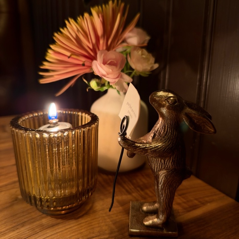 Picture of a small gold rabbit statue, candle, and flower at H&F last night.