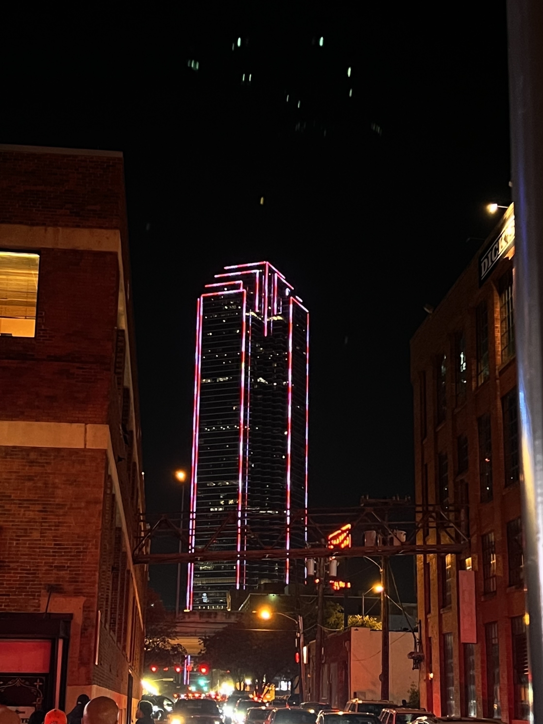 Dallas night skyline. Skyscraper with candy cane red and white lights surrounding silhouette of the skyscraper. 