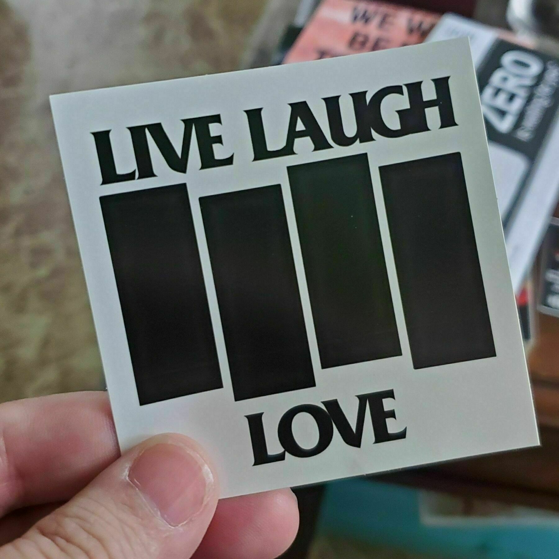 A sticker with the Black Flag logo which replaces "Black Flag" with "Live Laugh Love"