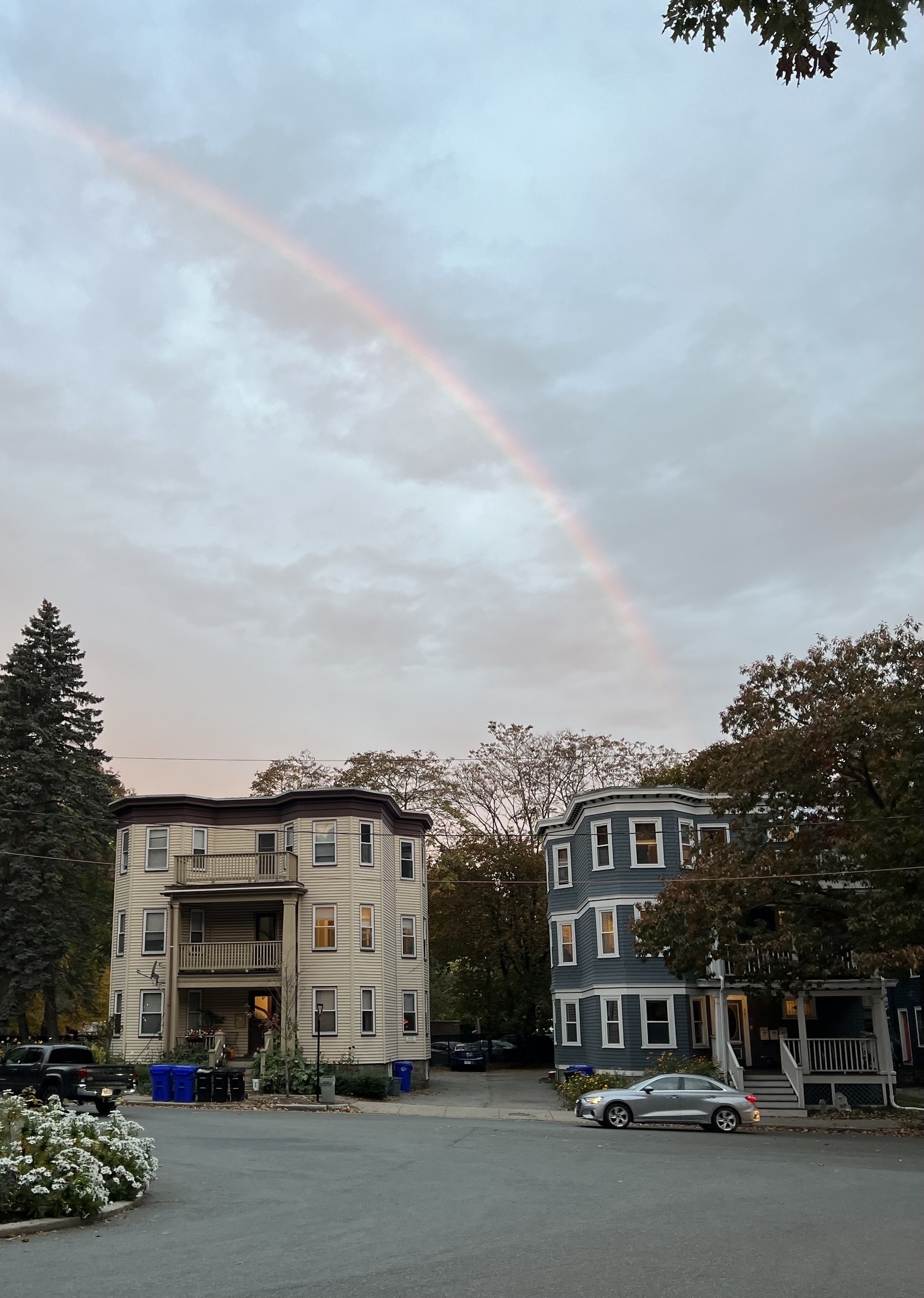A rainbow arches over two triple-decker houses in Brookline, MA.