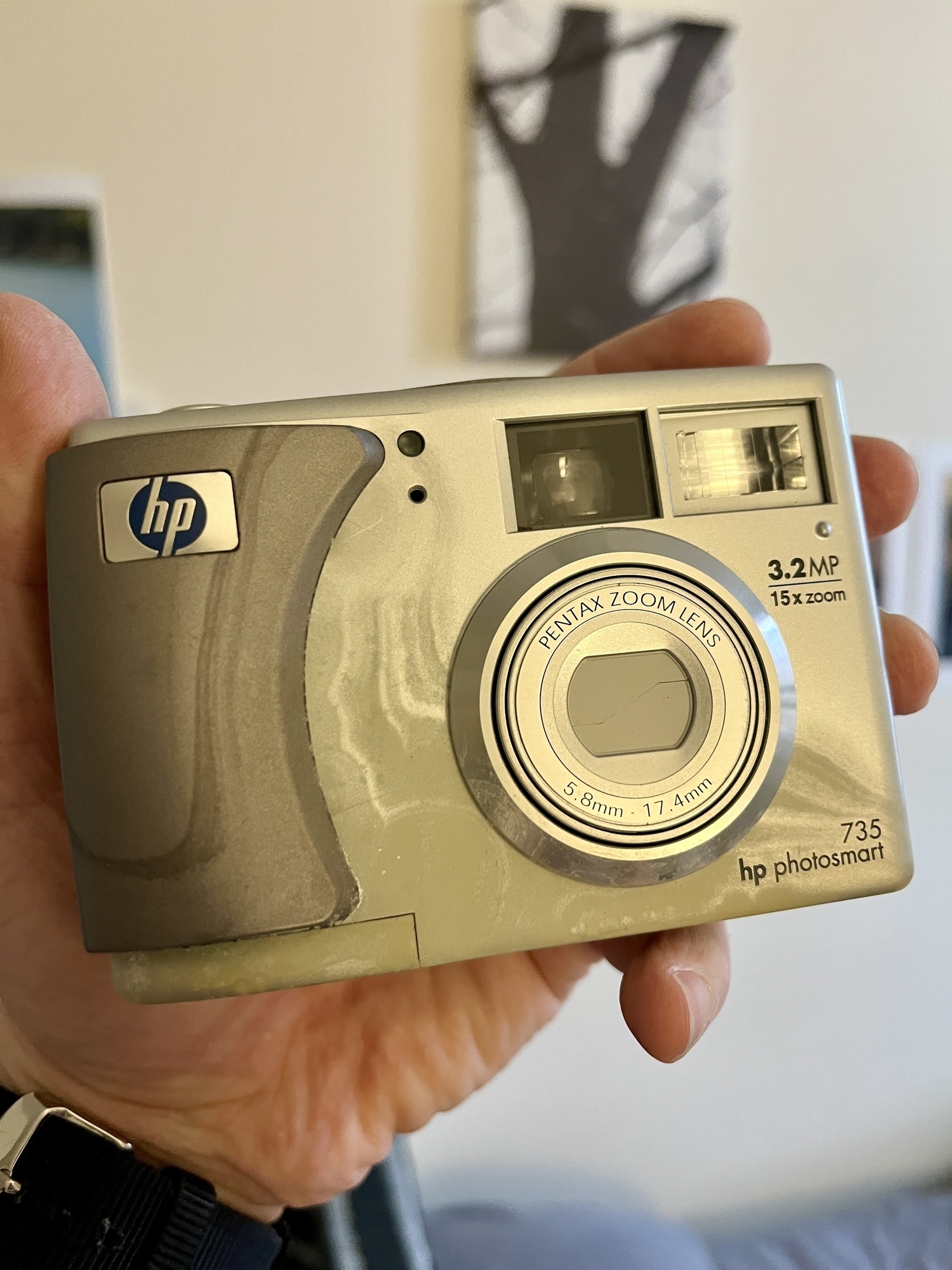 A hand holding an HP camera. It’s a photosmart 753 model. 