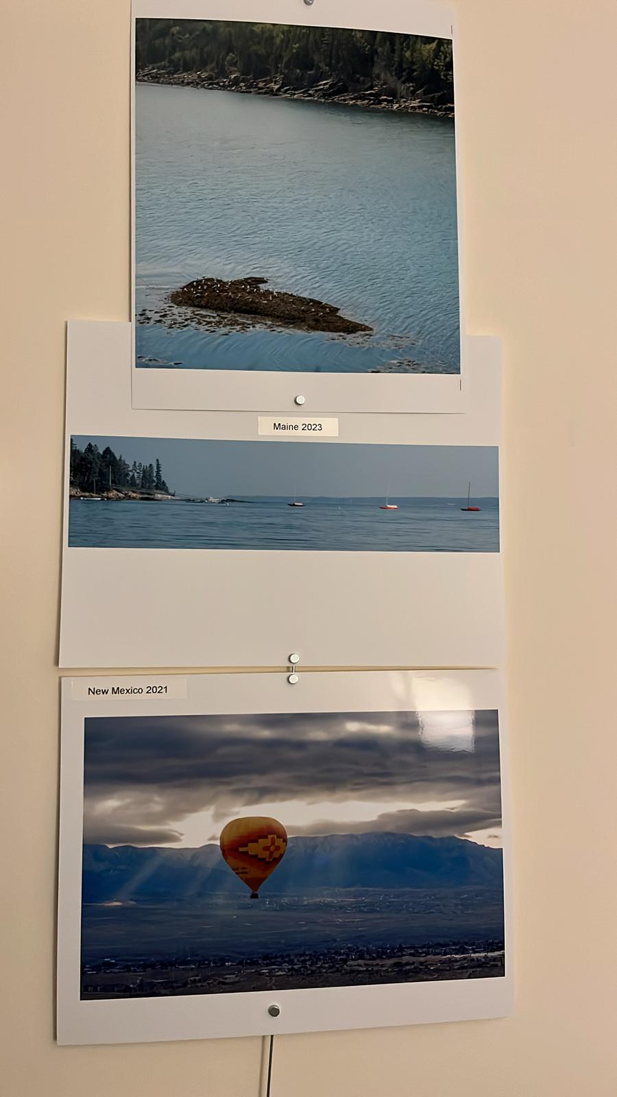 printed photos of places in Maine, and one of a hot air balloon in New Mexico
