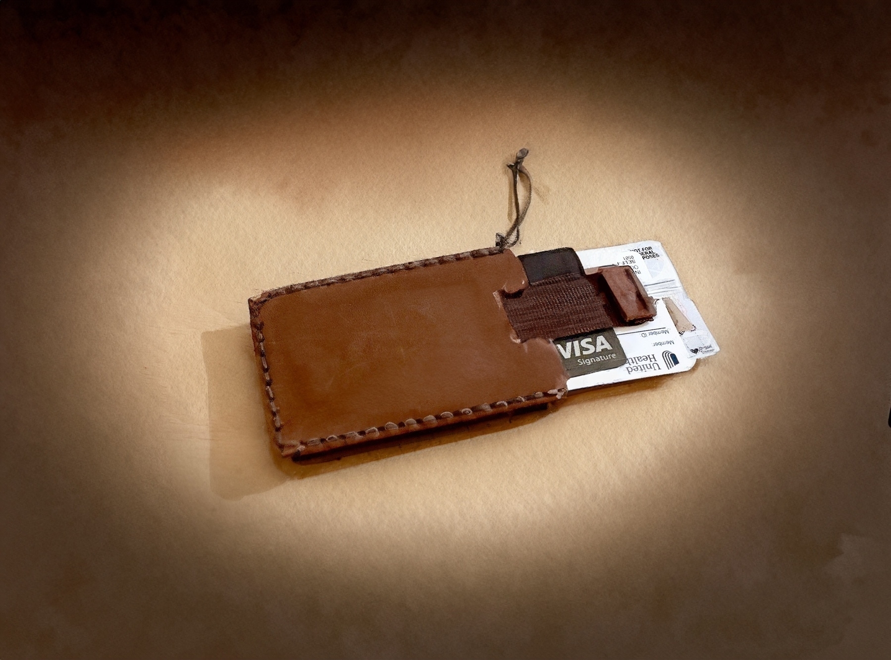 A leather cardholder with a Visa credit card and a health insurance card partially visible inside.