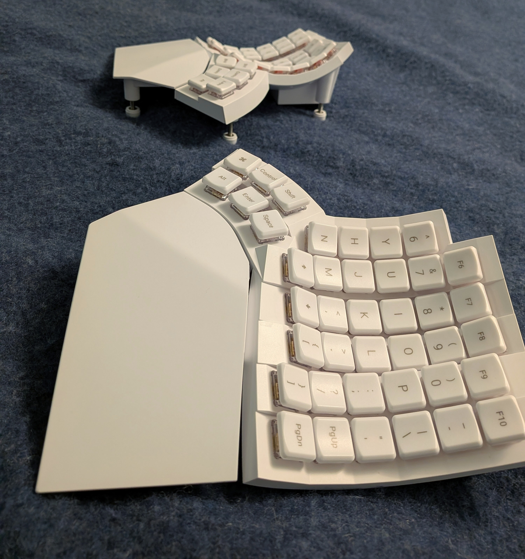 The uniquely-designed ergonomic split keyboard glove80. Its key sections are curved, called keywells.