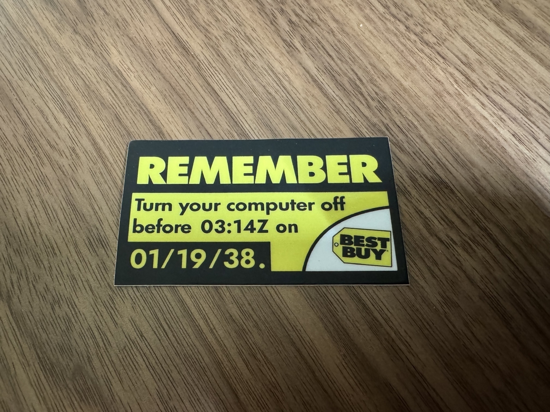 A black and yellow sticker in the style of Best Buy’s Y2K warning but with the time and date changed to 3:14 on 1/19/2038. 