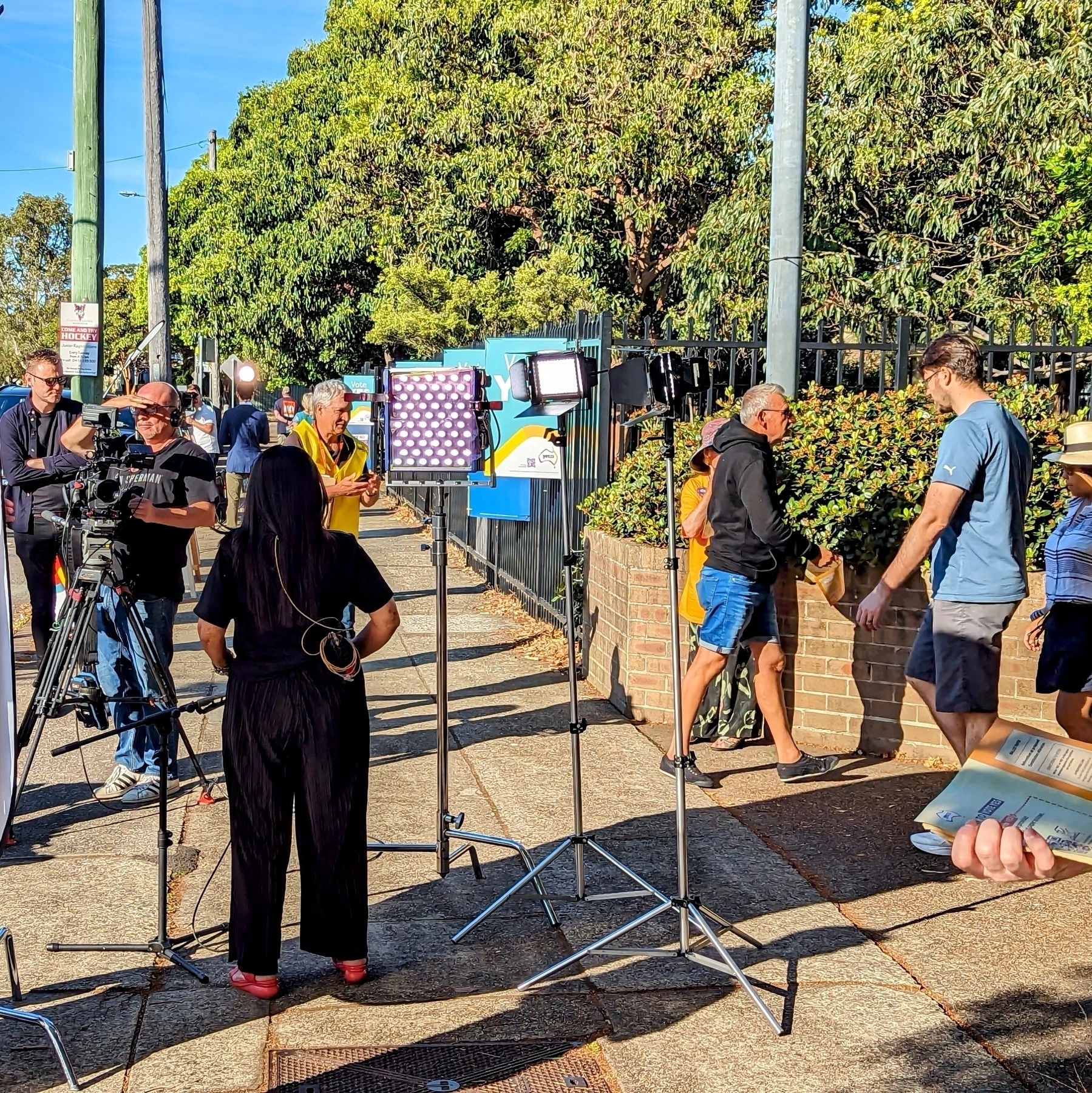 A rear view of Linda Burney, Minister for Indigenous Australians, as she addresses the TV camera on the morning of the referendum on an Indigenous voice to Parliament. She’s standing outside a polling place near Kamay Botany Bay 