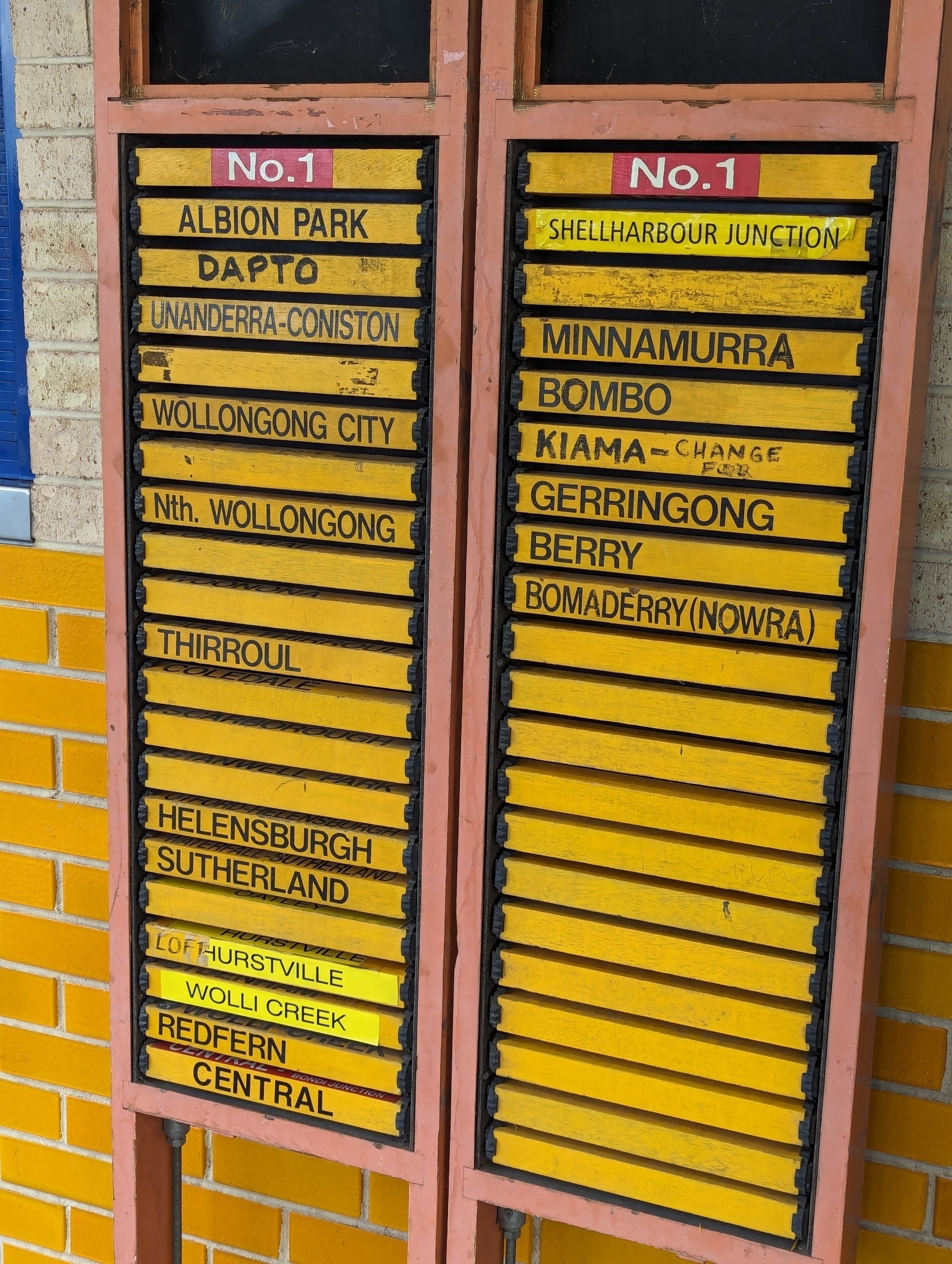 A mechanical destination board at a railway station. The destination stations for the next trains to depart are written on small yellow boards which revolve. 