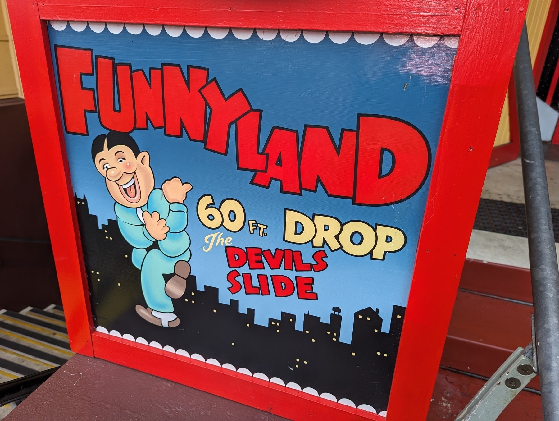 A sign at a traditional funfair promotes Funnyland and the Devil's slide.