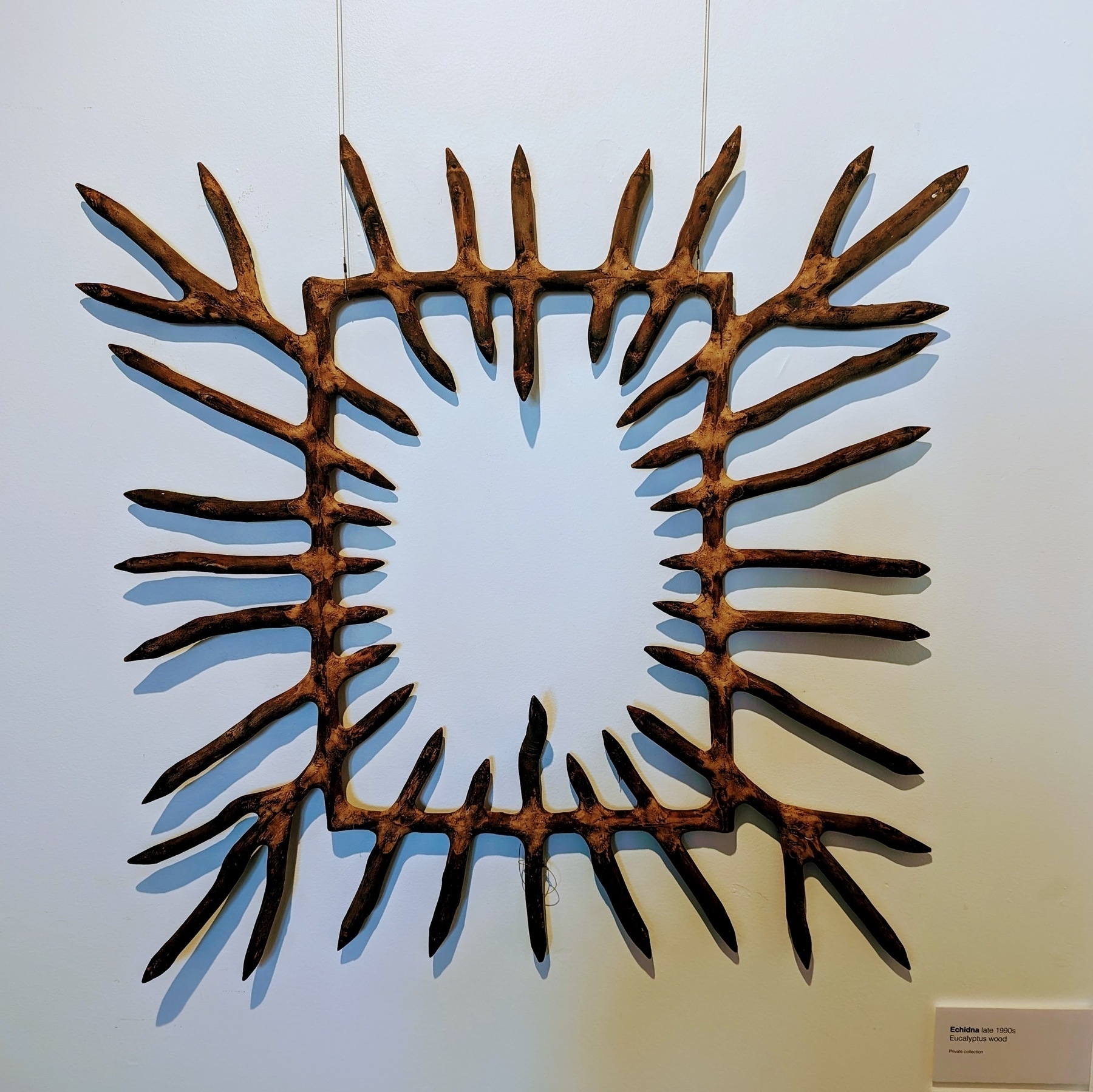 An artwork made of sticks pointing inwards to form a rectangle. The void in the centre is reminiscent of an echidna