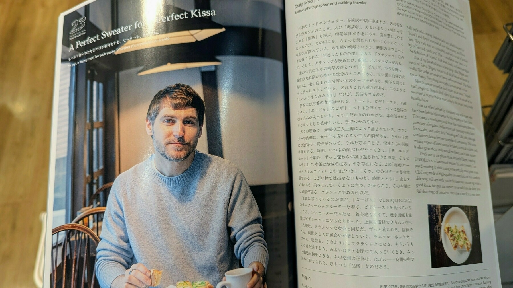 Author and walker Craig Mod in a sweater is seated at a table with pizza toast, featured in a magazine, which includes both English and Japanese text.