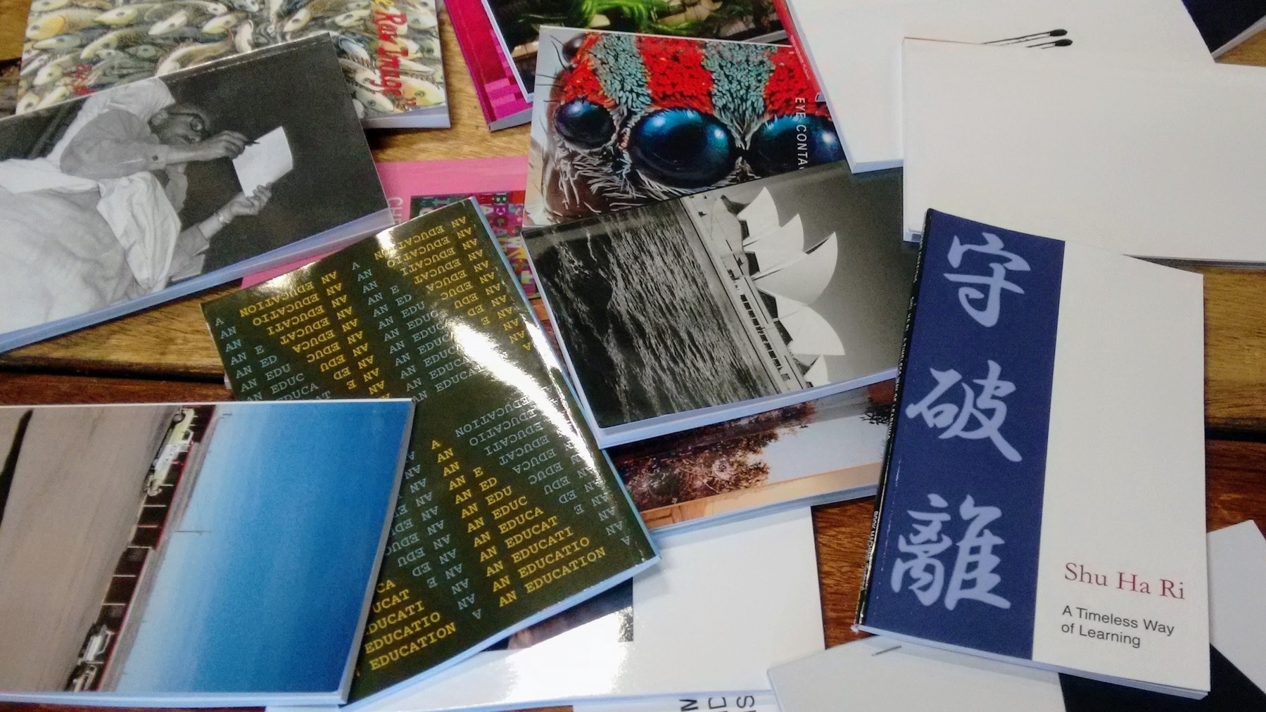A A collection of various colorful books and cards scattered on a wooden surface.