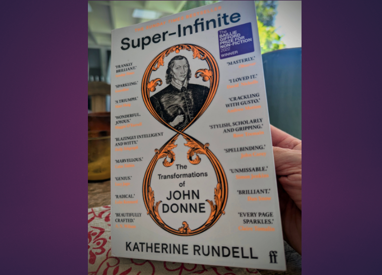 Auto-generated description: A person is holding a book titled Super-Infinite: The Transformations of John Donne by Katherine Rundell, featuring a black and white illustration of John Donne on the cover.