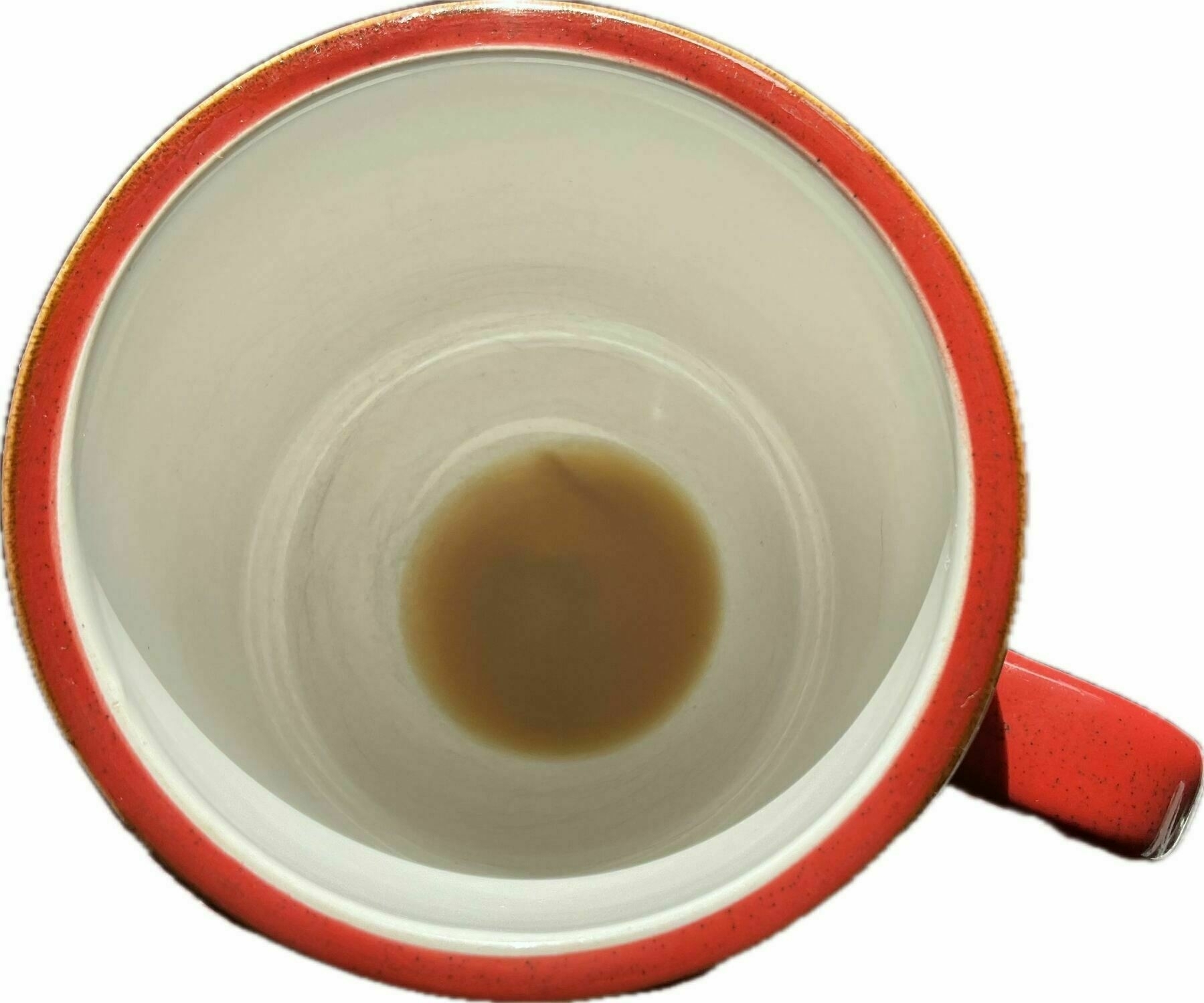 Red mug viewed from above with some coffee dregs in the bottom