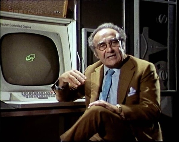 Jacob Bronowski sitting in front of a 1970's computer. Screenshot from The Ascent of Man series.
