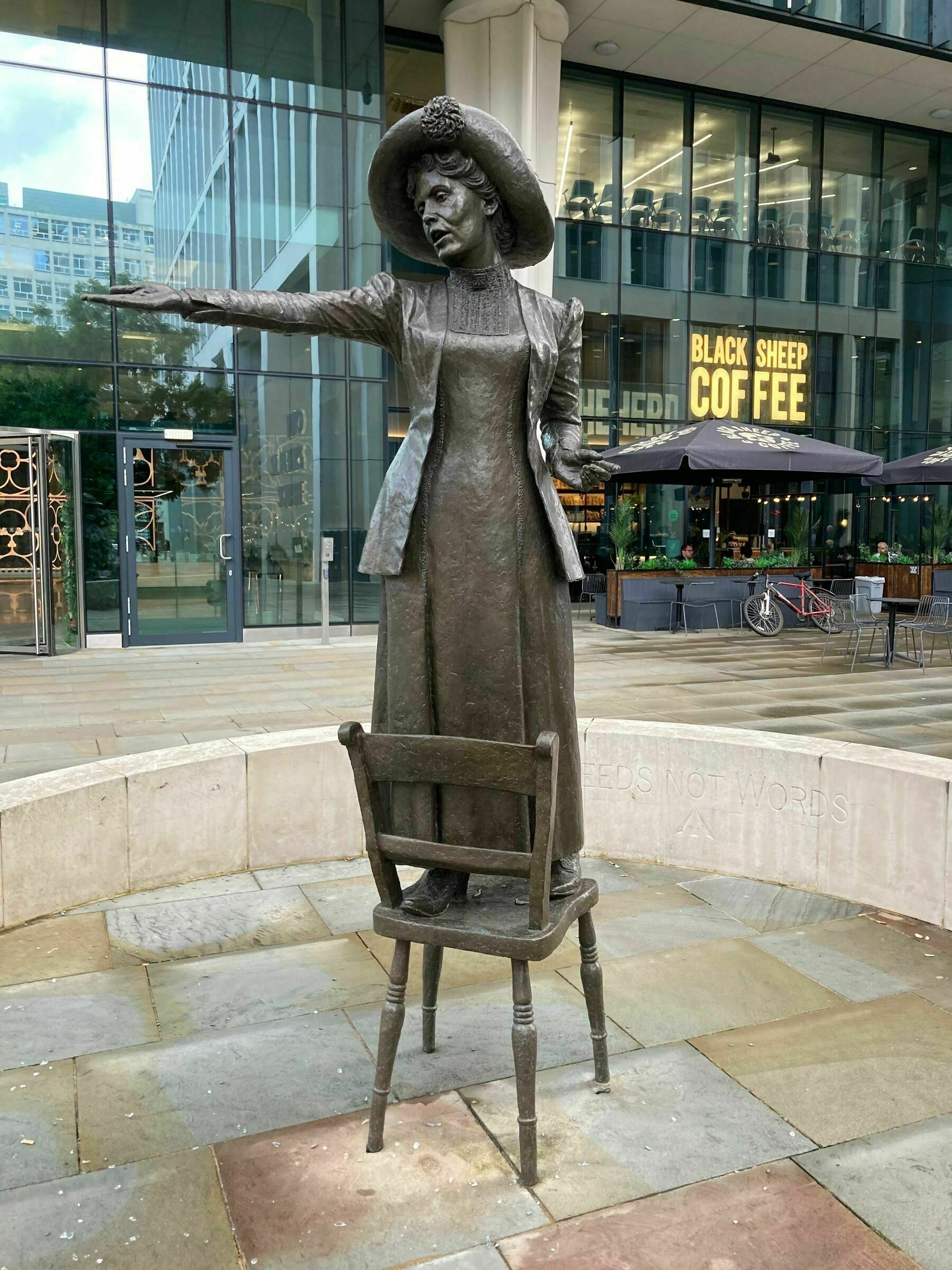 Statue of Emmeline Pankhurst giving a speech from a chair in Manchester UK