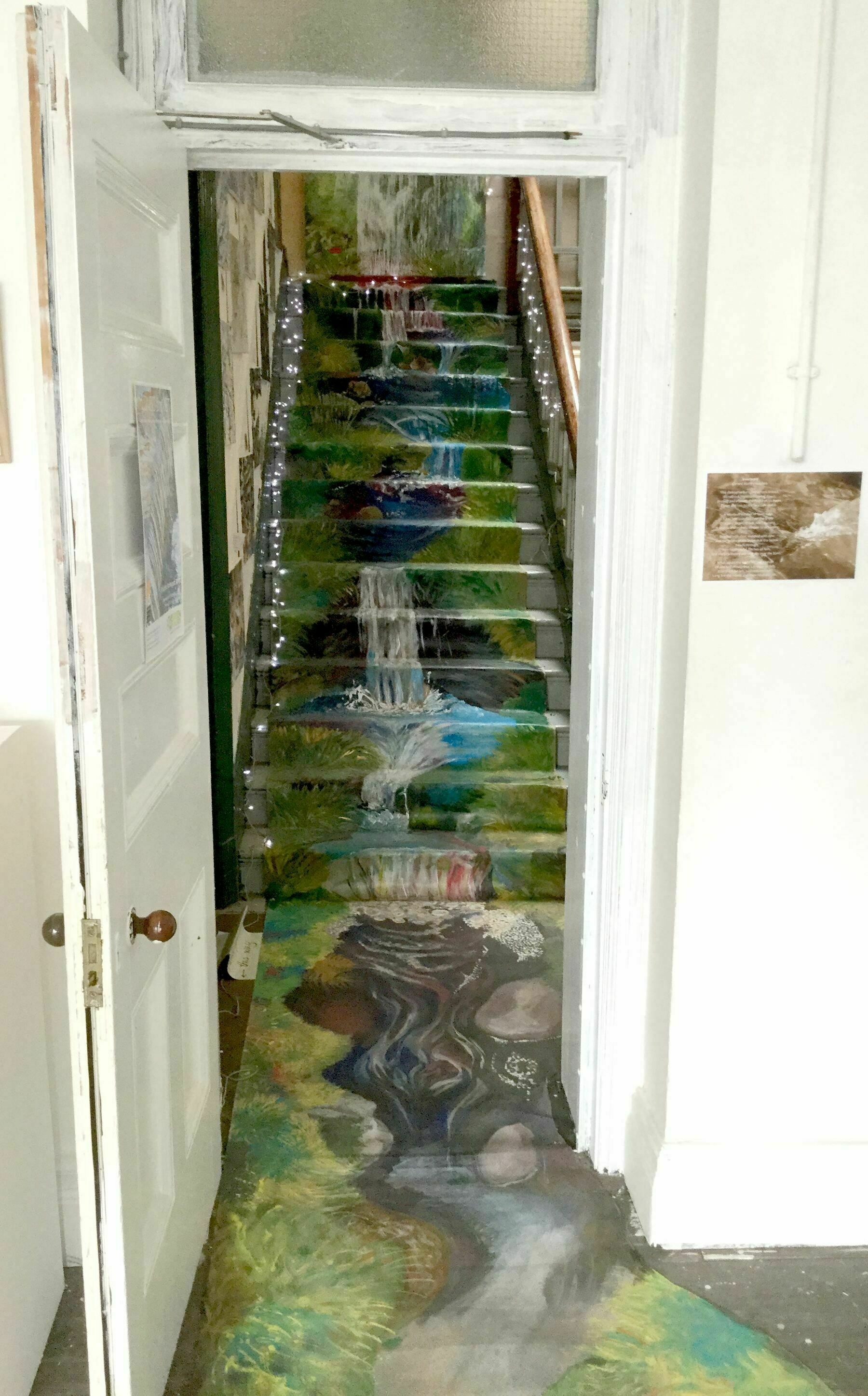A waterfall painted on to stairs and flowing through a doorway at the bottom.