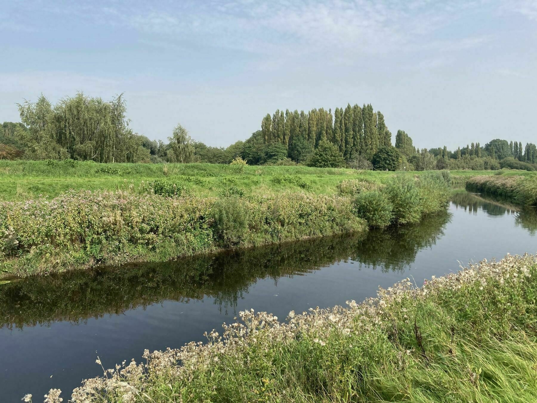 The river Mersey flowing through the tree lined meadows of south Manchester