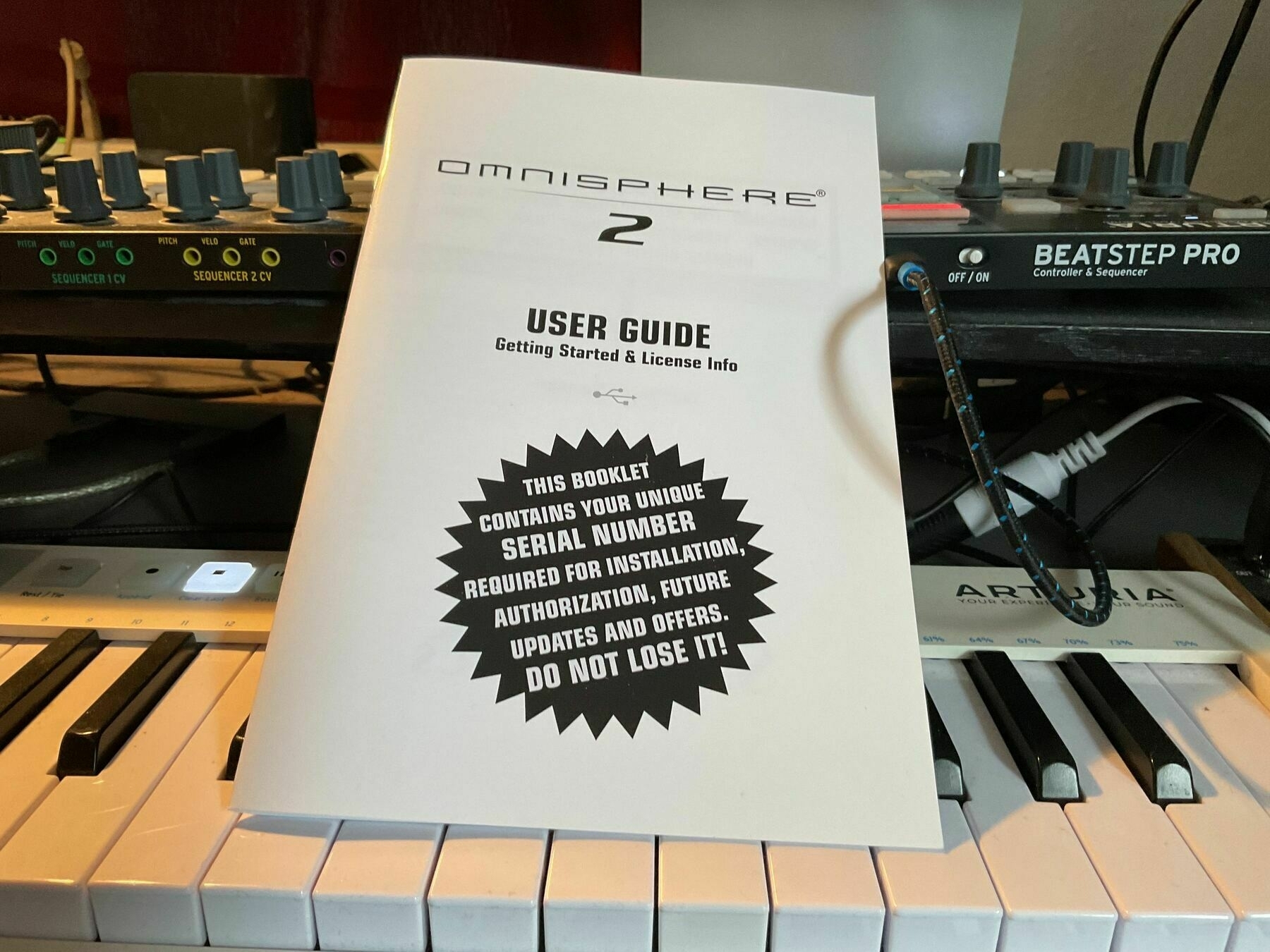A user guide for installing music software resting on a piano keyboad.