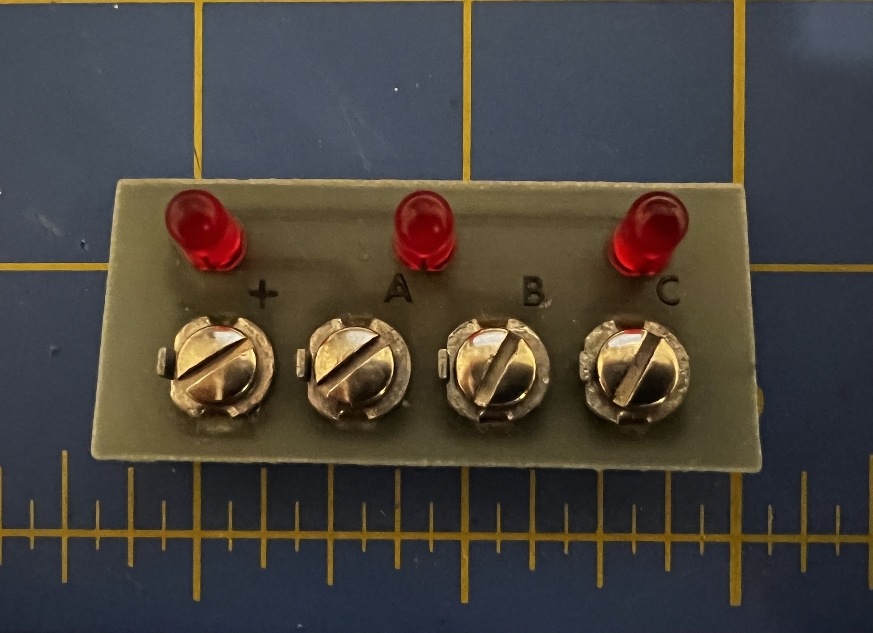 Three red LEDs on a circuit board with screw terminals 