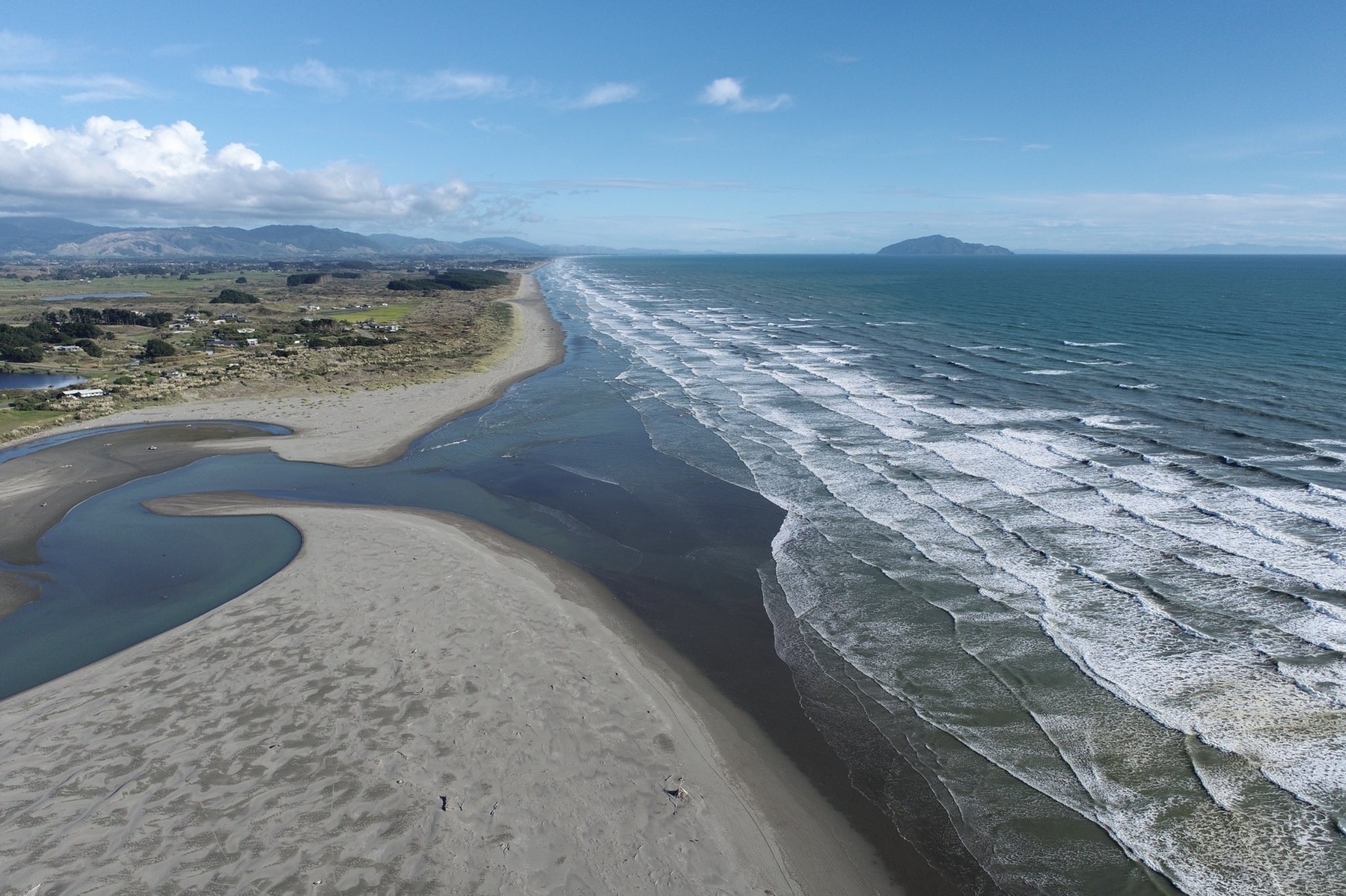 Looking south, with river mouth on the left and Kāpiti Island in the distance. 