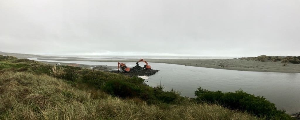 Wide view showing river and diggers. 