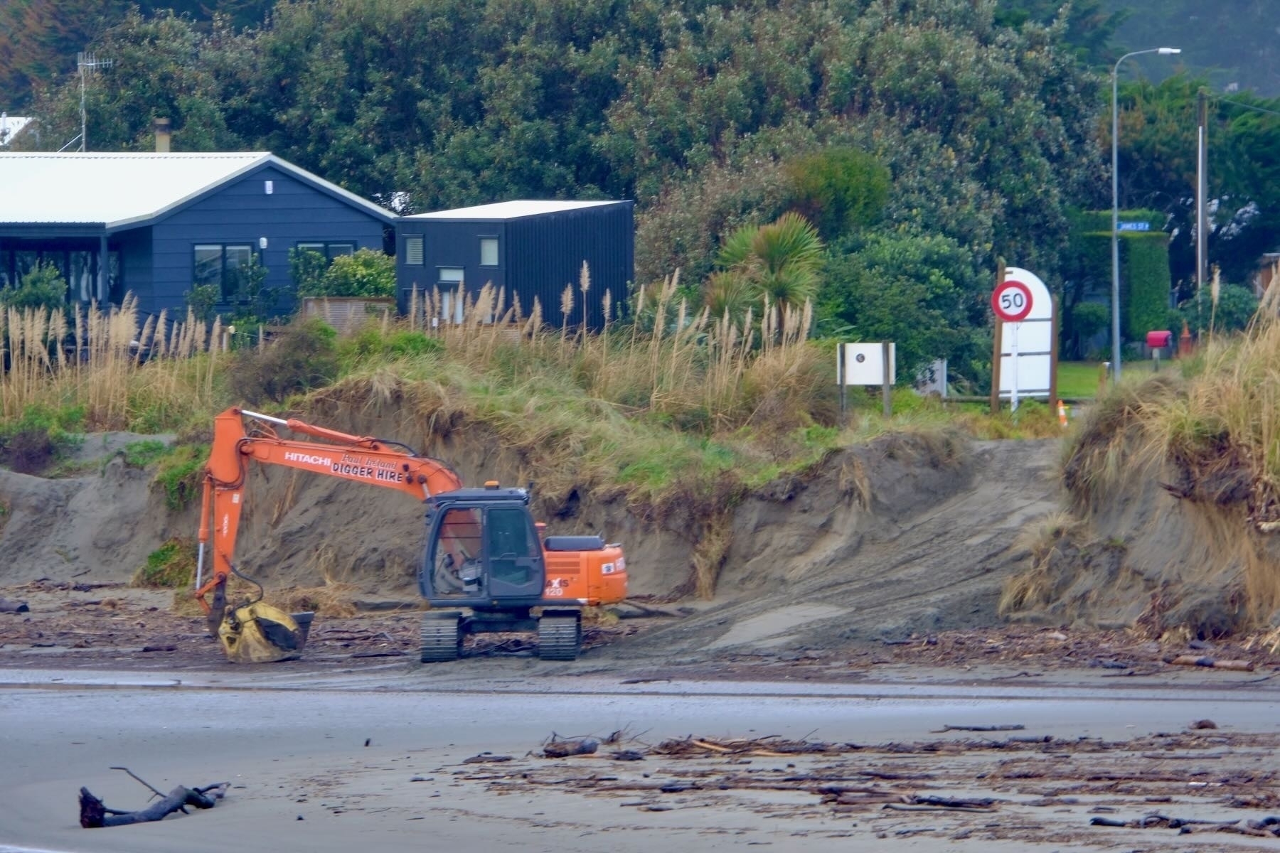 Digger on the beach in front of the track through Miratana land. 