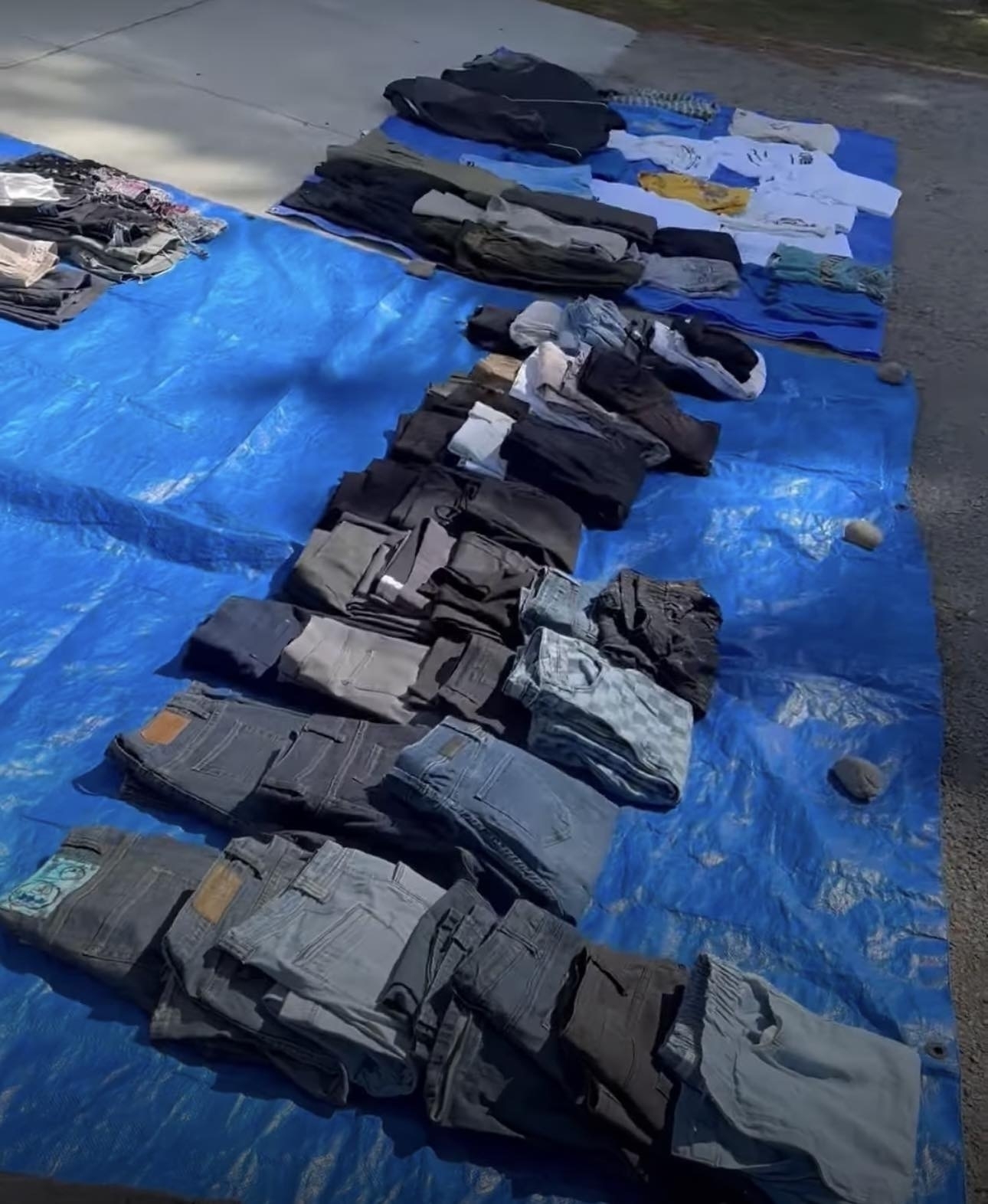Trousers and accessories laid out on a tarpaulin. 