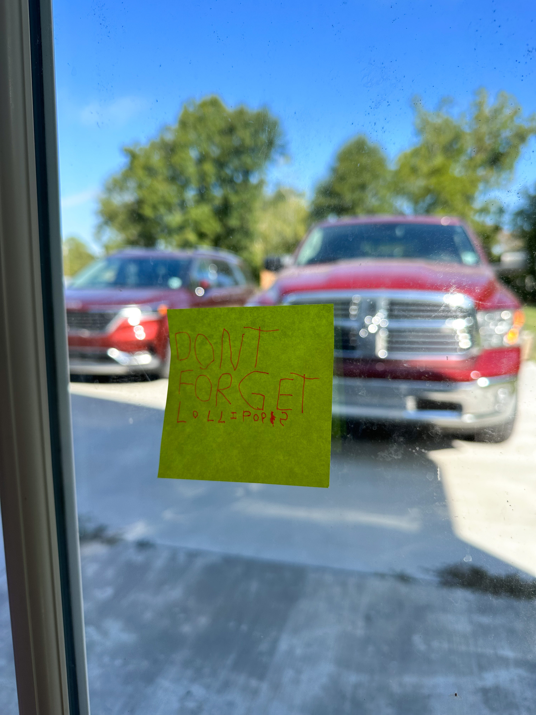 A sticky note on a window/door that says, “Don’t forget lollipops”