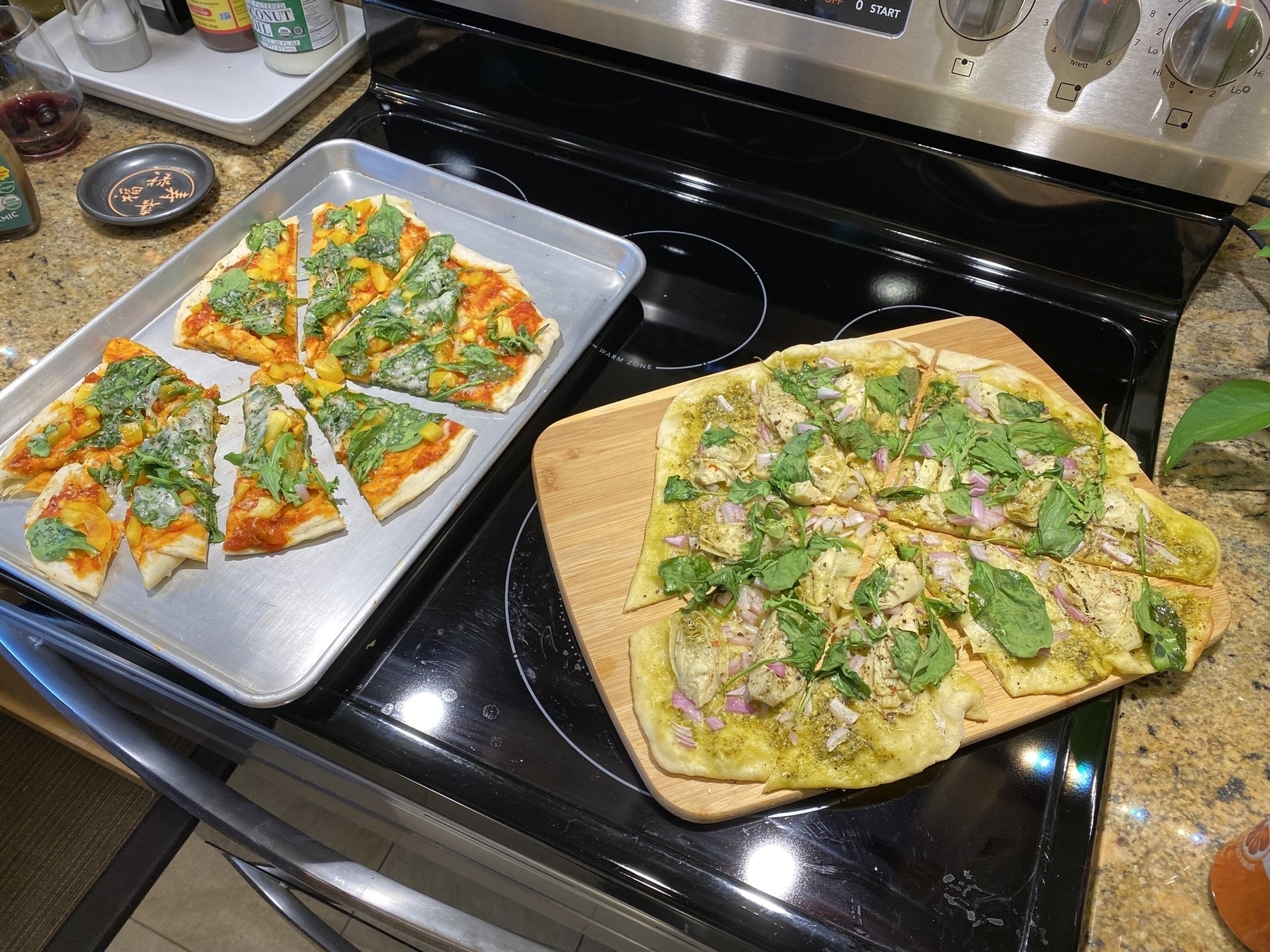 Two homemade pizzas on a stove top